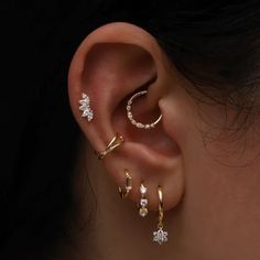 three different types of ear piercings in gold, silver and white colors with diamonds