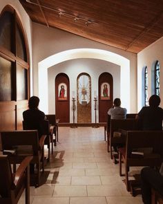 people sitting in pews at the end of a church