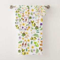 a towel hanging on the side of a wall with flowers and giraffes