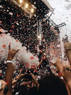 people are throwing confetti in the air at a concert