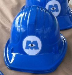 two blue hard hats sitting on top of a bed