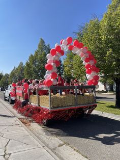 a parade float with balloons and hay in the back