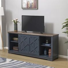 a flat screen tv sitting on top of a wooden entertainment center