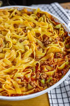 a casserole dish with meat and noodles in it on a wooden table top