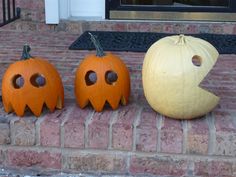 three carved pumpkins sitting on the front steps with holes in their mouths and faces