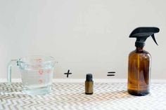 a bottle of essential oils next to an empty glass container with a sprayer on it