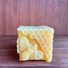 a soap bar with honeycombs and a bee on the inside, sitting on a wooden surface