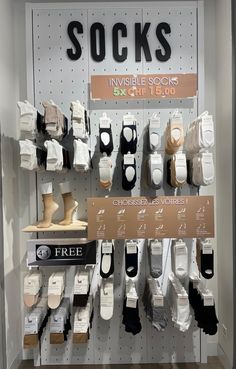 socks are displayed on display in a shoe store with free shipping signs above the shelves