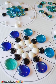 four different colored marbles are arranged on a white surface with black and blue circles