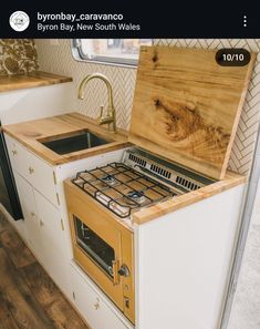 a kitchen area with an oven, sink and stove in the middle of wood flooring