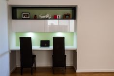 two black chairs sitting in front of a white desk