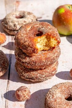 several donuts stacked on top of each other next to an apple and cinnamon roll