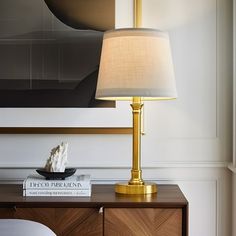 a lamp on a table next to a book