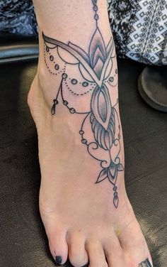 a woman's foot with a tattoo design on the top and bottom of it