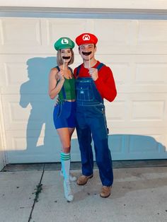 two people dressed as mario and luigi in front of a garage door