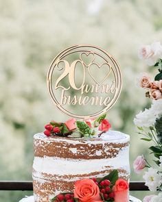 a wedding cake with flowers and greenery on top