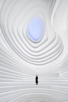 a man is standing in the middle of a room with white walls and ceilinging