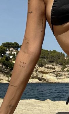 a woman's legs with tattoos on the beach