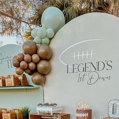 a football themed birthday party with balloons and desserts on the table in front of a large sign