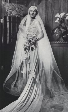 an old black and white photo of a woman in a wedding dress with veil over her head