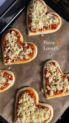 heart shaped pizzas with cheese and sauce on a baking sheet in the shape of hearts