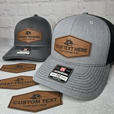 three hats with leather patching on them sitting next to each other, one is gray and the other has black brimmed