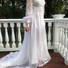 a woman in a white dress standing on a deck