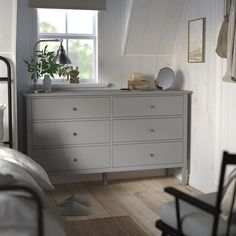 a bedroom with a bed, dresser and window