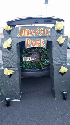 the back of a car is decorated with plastic wrap and yellow tissue paper, which says jurassic park