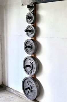 a row of metal weight plates mounted to the side of a wall