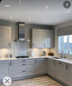 a kitchen with grey cabinets and white counter tops