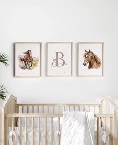 a baby's room with three framed pictures on the wall and a crib