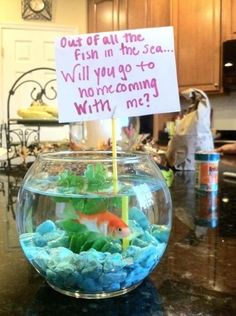 a fish bowl with a sign on it that says, out of all the fish in the sea will you go to swimming with me?