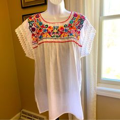 Nwot White Peasant Blouse W/Multi Color Embroidery. Size Medium Cotton No Size Or Fabric Tags, Purchased In Spain 21” From Armpit To Armpit Lying Flat 29” Long White Crew Neck Blouse With Floral Embroidery, White Embroidered Crew Neck Blouse, White Folk Style Peasant Top For Vacation, White Folk Peasant Top For Vacation, Peasant Floral Embroidered Top For Beach, White Short Sleeve Peasant Blouse, White Peasant Blouse With Short Sleeves, White Embroidered Hem Blouse For Vacation, White Peasant Top With Chikankari Embroidery For Summer