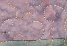 a close up of a piece of cloth with stitching on it and some thread