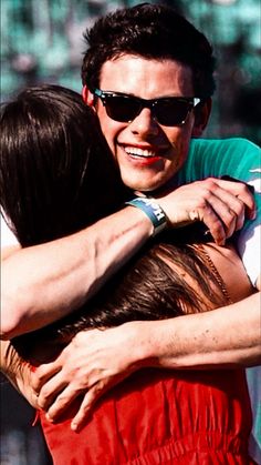 two people hugging each other while wearing sunglasses