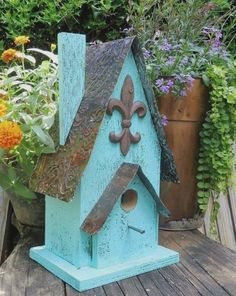 a blue birdhouse with a fleur de lis on it's roof