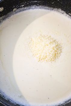 a pan filled with cheese and milk on top of a stove