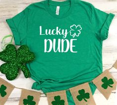 a st patrick's day t - shirt with shamrocks next to it