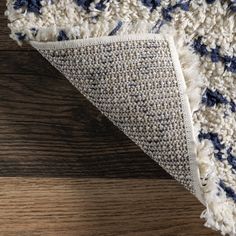 a blue and white area rug on top of a wooden floor next to a piece of wood