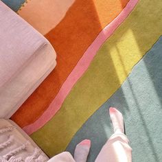 someone's feet on a rainbow colored rug