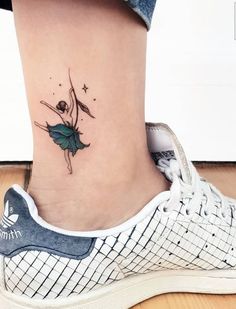 a woman's foot with a small tattoo on the side of her leg and a flower