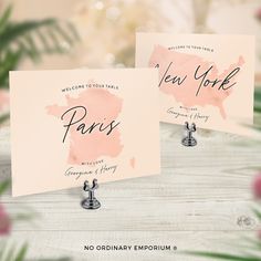 two pink cards with the words new york and paris on them