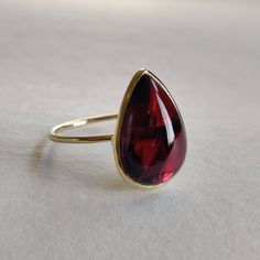 ITEM DESCRIPTION: >>The ring is made from Solid 14K Yellow Gold. >>Gemstone used is absolutely natural and ethically sourced. >>Natural Garnet in pear Shape and bezel setting is studded on it with utmost precision. Gem: Garnet Gem size & shape: 10x15mm Gem weight: 7.55 Carats Gold purity: 14K (58.33% approx.) Gold weight: 0.98 grams Gross weight of ring: 2.49 grams The Gold purity is guaranteed and it comes with authentic 14K gold hallmark. Since these Rings are handmade, they are Nickel/Lead FR Formal Teardrop Bezel Setting Rings, Modern Pear-shaped Rings As Gift, Pear-shaped Ring With Bezel Setting For Formal Occasions, Formal Pear-shaped Ring With Bezel Setting, Formal Pear-shaped Bezel Set Ring, 14k Gold Pear-shaped Ring With Bezel Setting, Elegant Cabochon Teardrop Ring, Pear-shaped Cabochon Ring As Gift, Elegant Teardrop Cabochon Ring