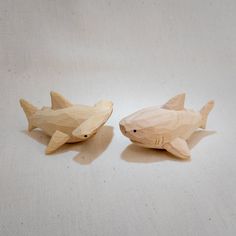 two wooden shark figurines sitting next to each other