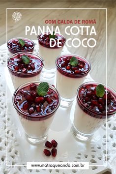 four glasses filled with pudding sitting on top of a white doily and topped with cherries