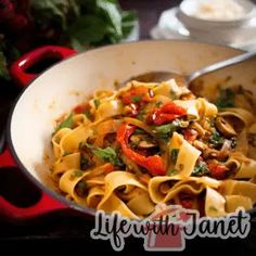 a pan filled with pasta and vegetables on top of a table