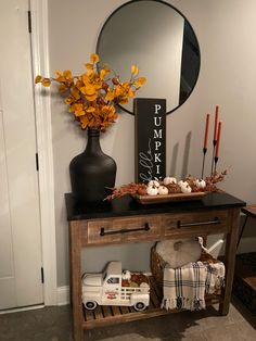 a wooden table topped with a mirror next to a vase filled with flowers and candles