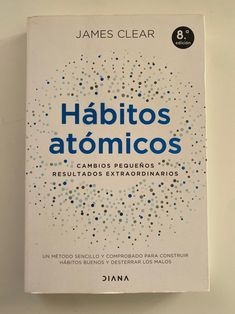 the book habitos atonicos by james clear is displayed on a wall