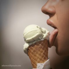 a woman eating an ice cream cone with her tongue out